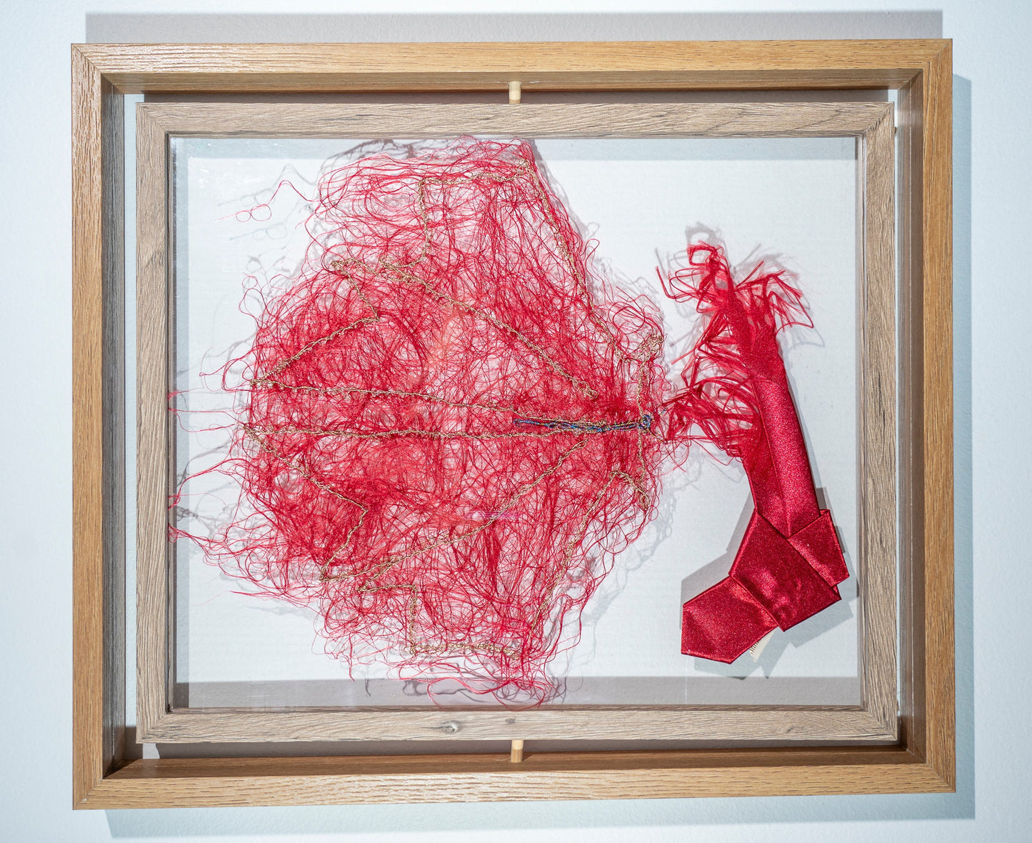 it is made from another bright red tie that has been shredded into a cloud out red threads with the suggestion of a maple leaf picked out in gold thread. it king of looks like a maple leaf moth perched on the loud red tie branch. again it is a version of how Canada responded to the USA's recent aggression. the tie is trumps red and made in china. it can be viewed from both sides