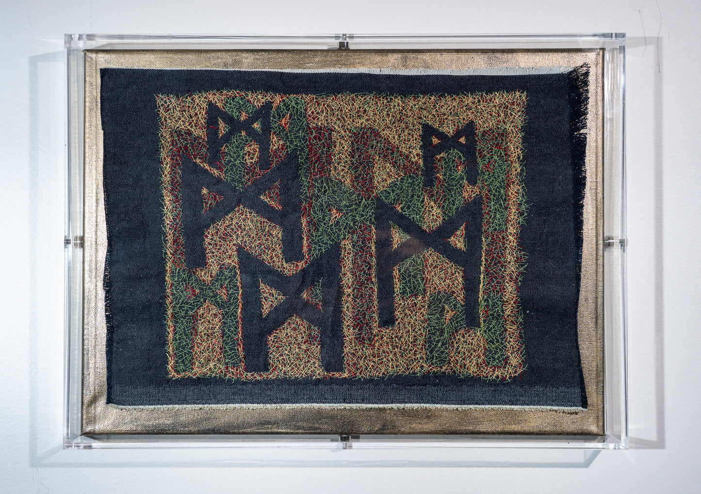 this is a very detailed piece consisting of three layers of embroidery that reveal mulitple versions of the rune mannaz in the spaces left empty. on frayed denim in tiny stitches to remind one that balance takes lots of tiny adjustments in a working world