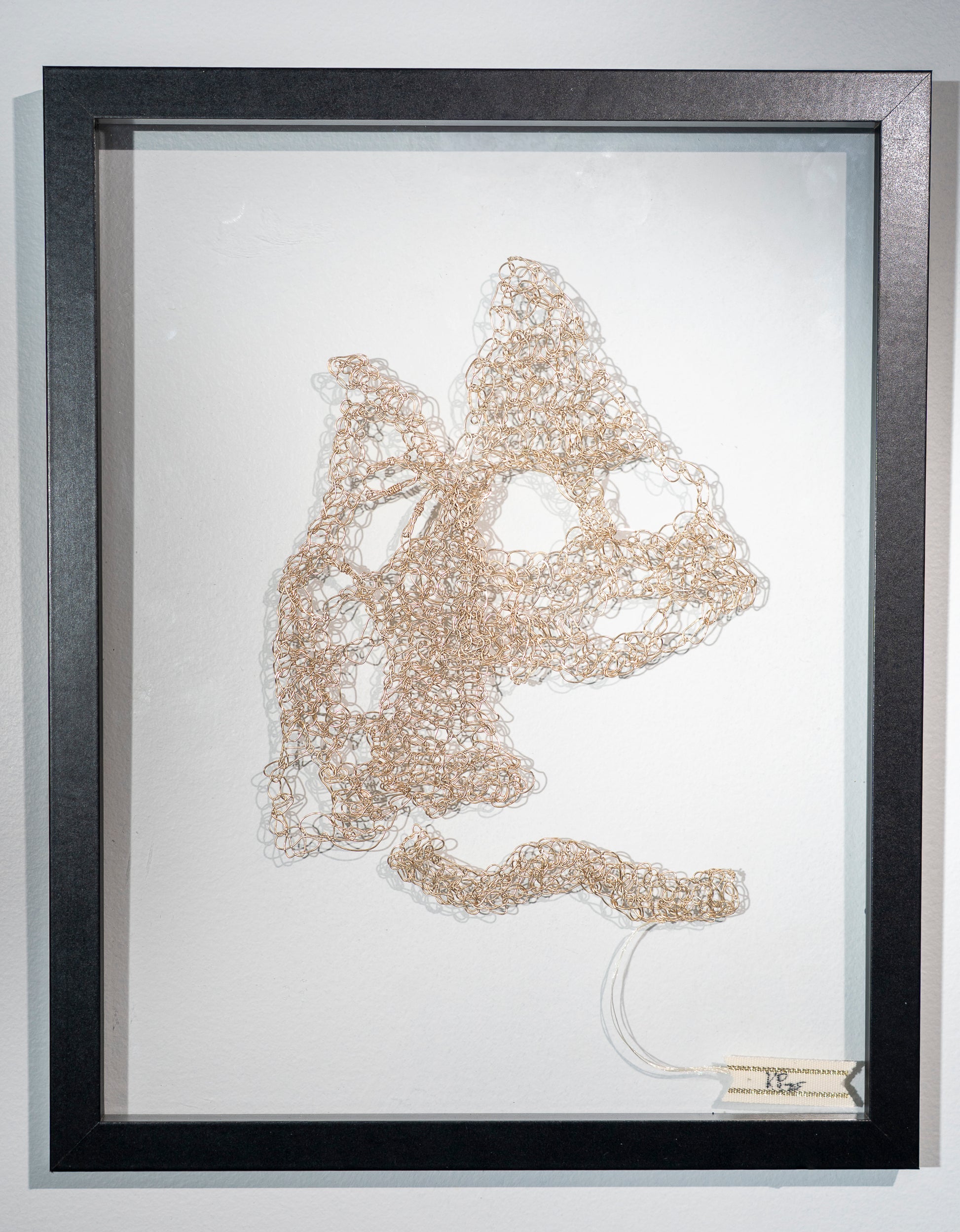 a crocheted golden colored wire that has been hammered flat. It is made into the shape of two mountains and a path leading towards them. They have huge holes in the working and the one in the distance could be interpreted to have a ghostly face screaming.  I'm thinking of how they look shiny in the distance but are never what we expect and frequently cause as much harm in the frantic pursuit and abandoned dreams and resultant damage to self