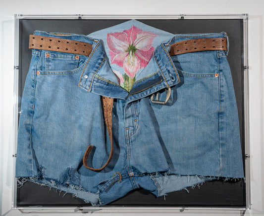 It is a pair of recycled men's jeans with worn leather belt, an open zipper and an amaryllis flower blooming from inside. I was thinking of gender norms and challenging assumptions